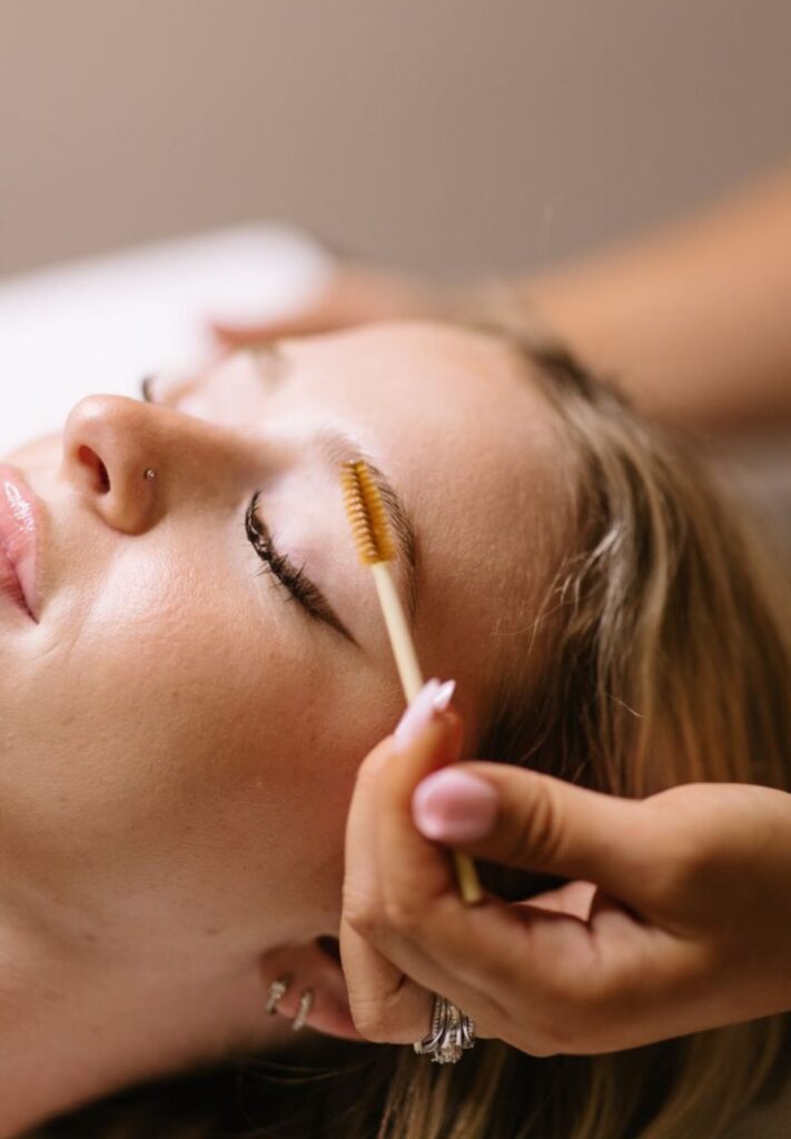 Aesthetician brushing a client's brows during a brow treatment at The MedSpa Raleigh